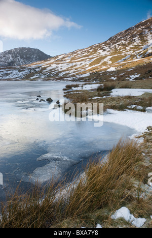 Frozen Styhead tarn in winter at the foot of Great Gable, with Lingmell beyond, Lake District, Cumbria Stock Photo