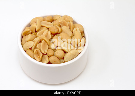 Small white bowl of salted peanuts Stock Photo