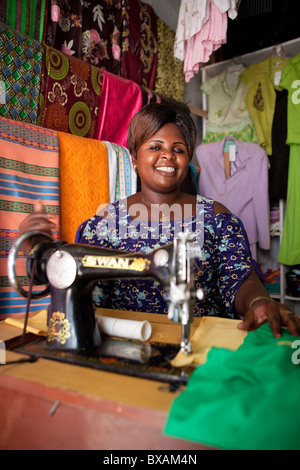 Ms. Juliet Mulebi sells clothing and performs alterations in her shop in the market in Iganga, Uganda, East Africa. Stock Photo