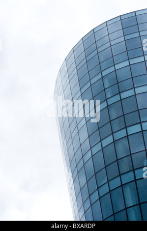 a half round glass multistory building widened upwards Stock Photo