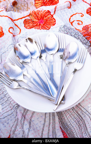 Spoons and forks on stack of plates Stock Photo