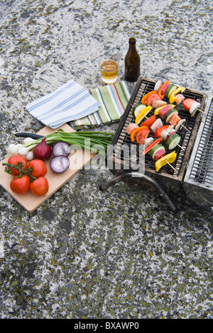 Barbecue grill with vegetables on rock Stock Photo