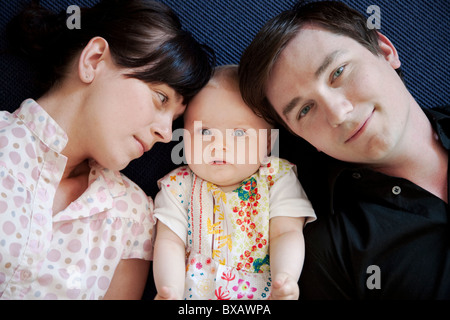Baby girl lying between father and mother Stock Photo