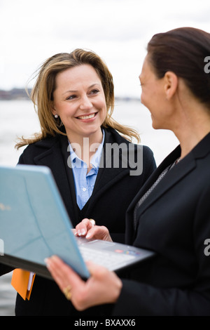 Pair of businesswomen working on laptop Stock Photo