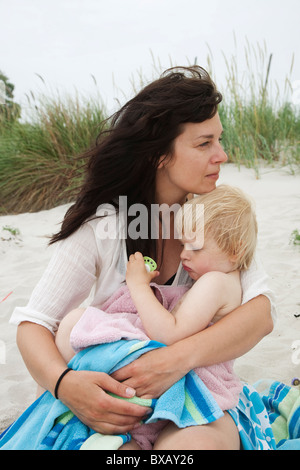 Mother and daughter sitting on beach