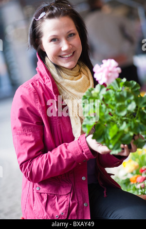 Portrait of young woman holding bunch of flowers Stock Photo