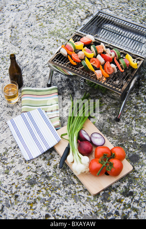 Barbecue grill with vegetables on rock Stock Photo