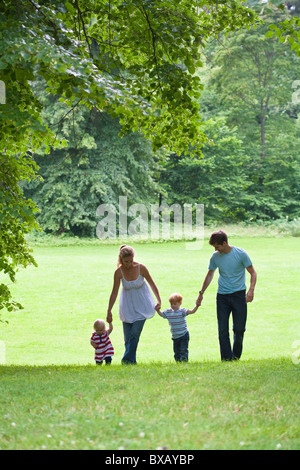 Mid adult couple with children walking in park Stock Photo