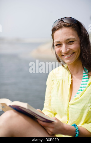 Woman reading book, smiling Stock Photo