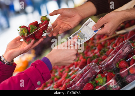 Woman paying for basket of strawberries Stock Photo