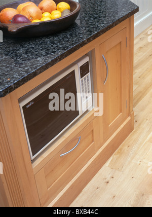Microwave and oven in island unit in modern kitchen with chrome Stock