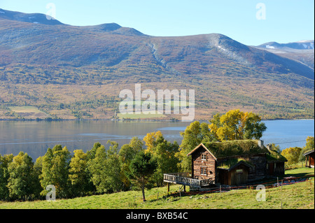 Wooden house on sea shore, mountain range in the background Stock Photo