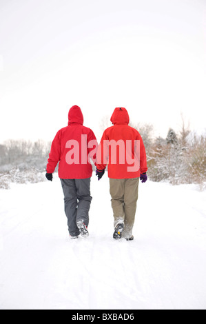 Two hikers walking through the snow Stock Photo
