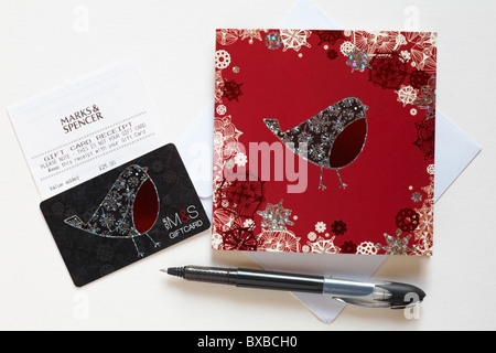 Getting ready to write out a M&S Christmas giftcard with robin on gift card isolated on white background Stock Photo