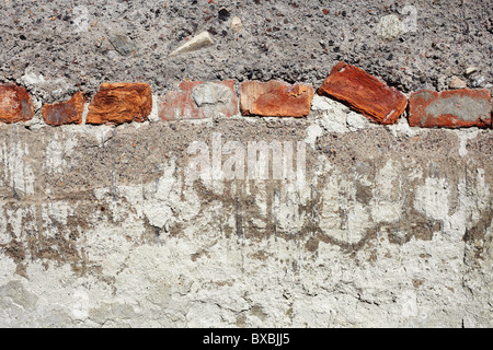 Multilayered concrete old wall with red bricks - background Stock Photo