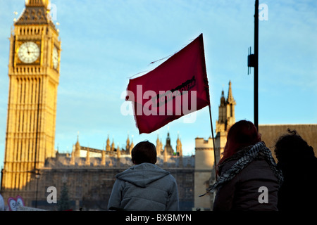 Protesters hold aloft a red flag 'Revolution' flag during tuition fees protest in Parliament Square, London. Stock Photo