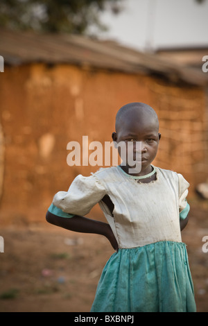 A young girl in a torn dress stands in Igamba village, Iganga District, Eastern Uganda, East Africa. Stock Photo