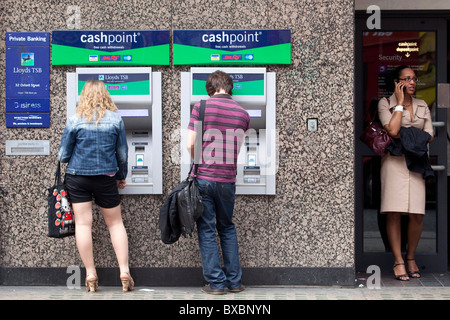 Woman and man at the cash machines of the Lloyds TSB Bank in London, England, United Kingdom, Europe Stock Photo