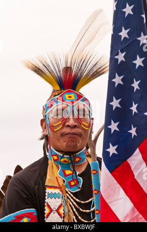 Adult male native warrior (First Nations), with American flag, at pow-wow, Blackfoot Crossing Historical Park, Alberta, Canada Stock Photo