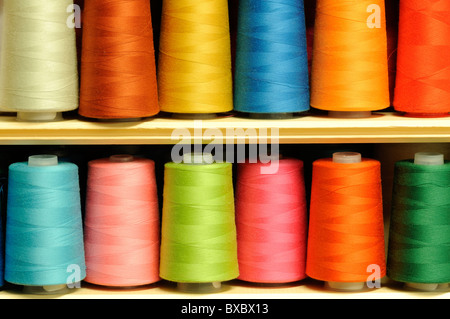 Group of multicolored sewing threads on shelf Stock Photo