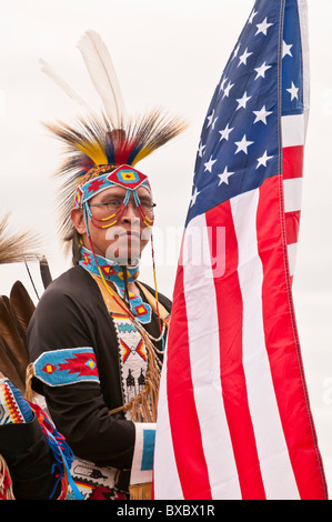 Adult male native warrior (First Nations), with American flag, at pow-wow, Blackfoot Crossing Historical Park, Alberta, Canada Stock Photo