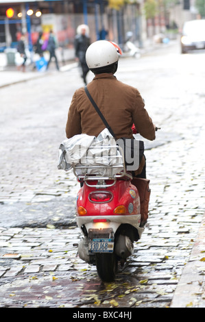 Back view of a person riding a scooter in Manhattan, New York City, U.S.A. Stock Photo