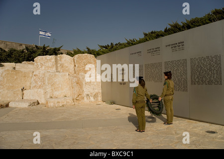 Two female soldiers laying a wreath at the Memorial Wall of the Armored Corps at the Israeli Armored Corps Museum at Latrun Stock Photo