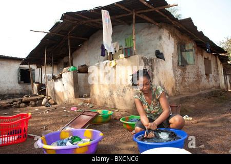 A woman washes clothes in a residential neighborhood in Freetown, Sierra Leone, West Africa. Stock Photo