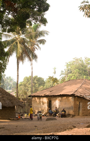 Villagers sit outside their house in Port Loko, Sierra Leone, West Africa. Stock Photo