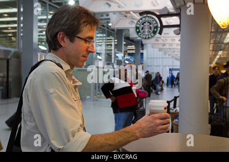 Customer with coffee at Starbucks coffee shop in airport, at Washington Dulles International Airport, DC, USA Stock Photo