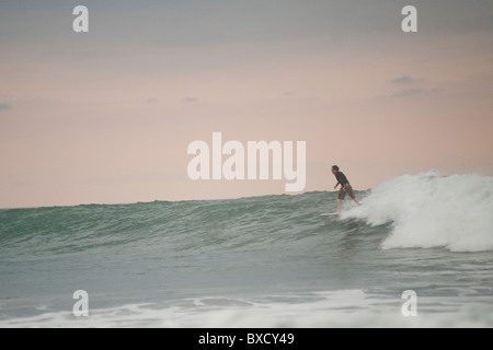 Surfer along Mal Pais coastline in San Jose Costa Rica Stock Photo