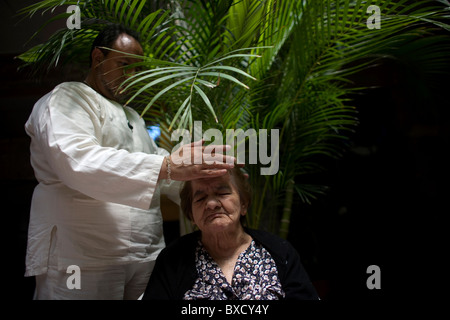 A woman receives Reiki at an elderly home for women in Mexico City Stock Photo
