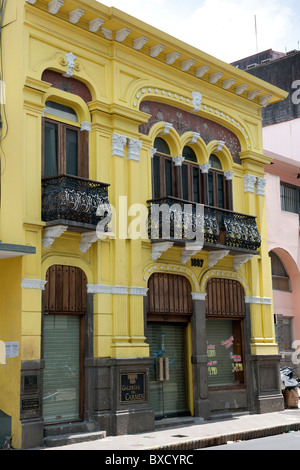 Yellow two storey building with wrought iron balcony and arched windows ...