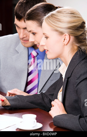 Portrait of three white collar workers sitting at the table Stock Photo