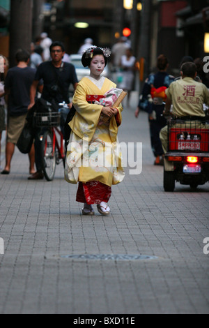 A maiko geisha walking to her appointment at a tea house on street in Gion district in Kyoto Japan Stock Photo