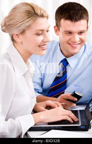 Image of woman typing on the keyboard and man holding the phone Stock Photo