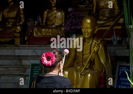 A woman worshipping at a shrine at Wat Phra That Doi Suthep in Chiang Mai in Thailand Stock Photo