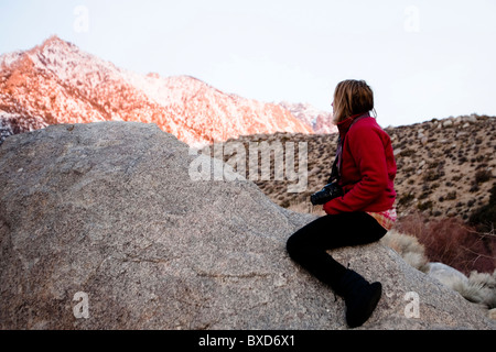 A woman watches the alpine glow on Mount Whitney from a campground in Lone Pine, California. Stock Photo