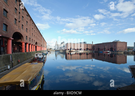 Albert Dock Liverpool Merseyside with blue sky and clouds reflected in the water, in the distance is the famous Liverbuildings. Stock Photo