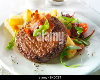 Char grilled beef burger and bacon with chunky chips and salad Stock Photo