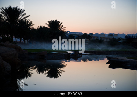 Reflected palm trees and sprinklers at the intercontinental resort at Soma bay in Egypt on the Read Sea near Safaga and Hurghada Stock Photo