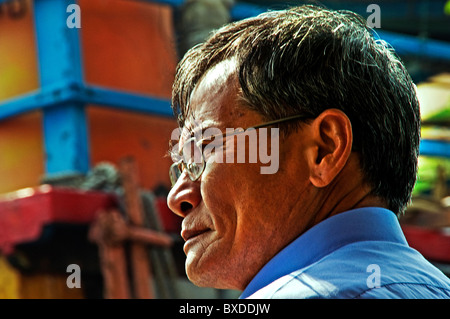 Asian man sitting on park bench in Hong Kong China Stock Photo
