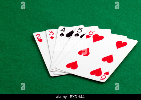 Poker hand with a straith on green felt Stock Photo
