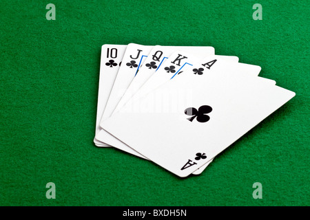 Royal Straith Flush poker hand with clubs on green felt Stock Photo