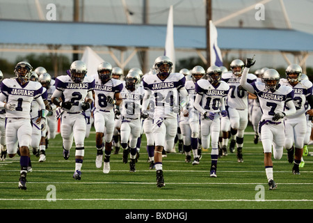 American high school football players run unto the field before kickoff at a game in Austin, Texas USA Stock Photo