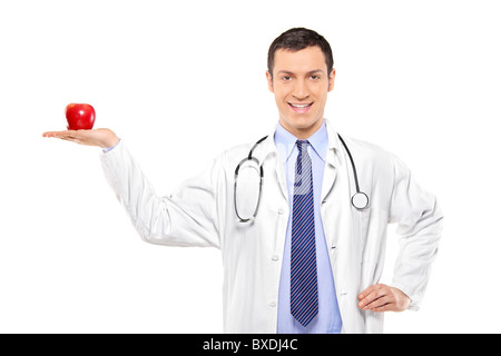 A male medical doctor with stethoscope holding a red apple Stock Photo