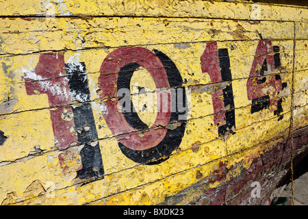 Number 1014 and peeling yellow paint on old fishing boat , Caldera , Chile Stock Photo