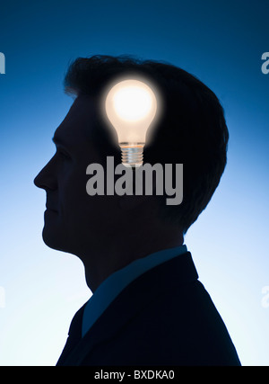 Light bulb in front of profile of a businessman Stock Photo