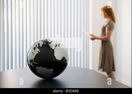 Globe on conference room table Stock Photo