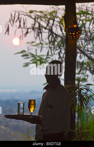 https://l450v.alamy.com/450v/bxdtge/waiter-serves-beer-as-the-sun-sets-stanley-safari-lodge-a-lodge-that-bxdtge.jpg